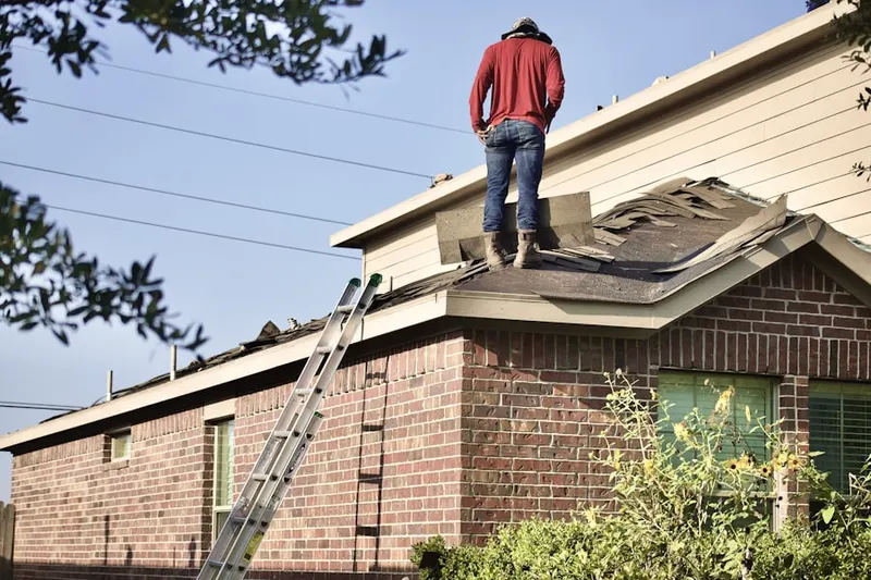 Professional roofer working on a residential roof in Kasson